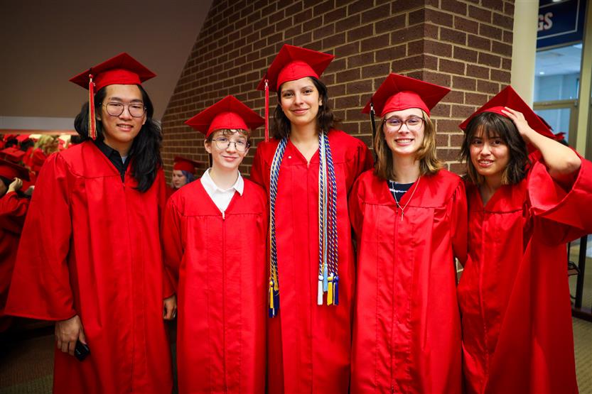 Students in red robes graduate